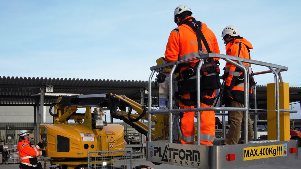 Arbeit mit Zweiwege Steiger zwei Monteure stehen in der Hubarbeitsbühne eines Zweiwege Steigers